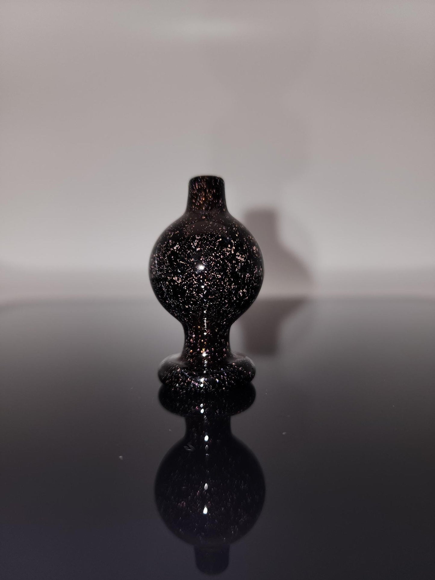 BSG Dichro Bubble Cap in hand, demonstrating its ergonomic design for a comfortable grip and easy handling during dabbing sessions.