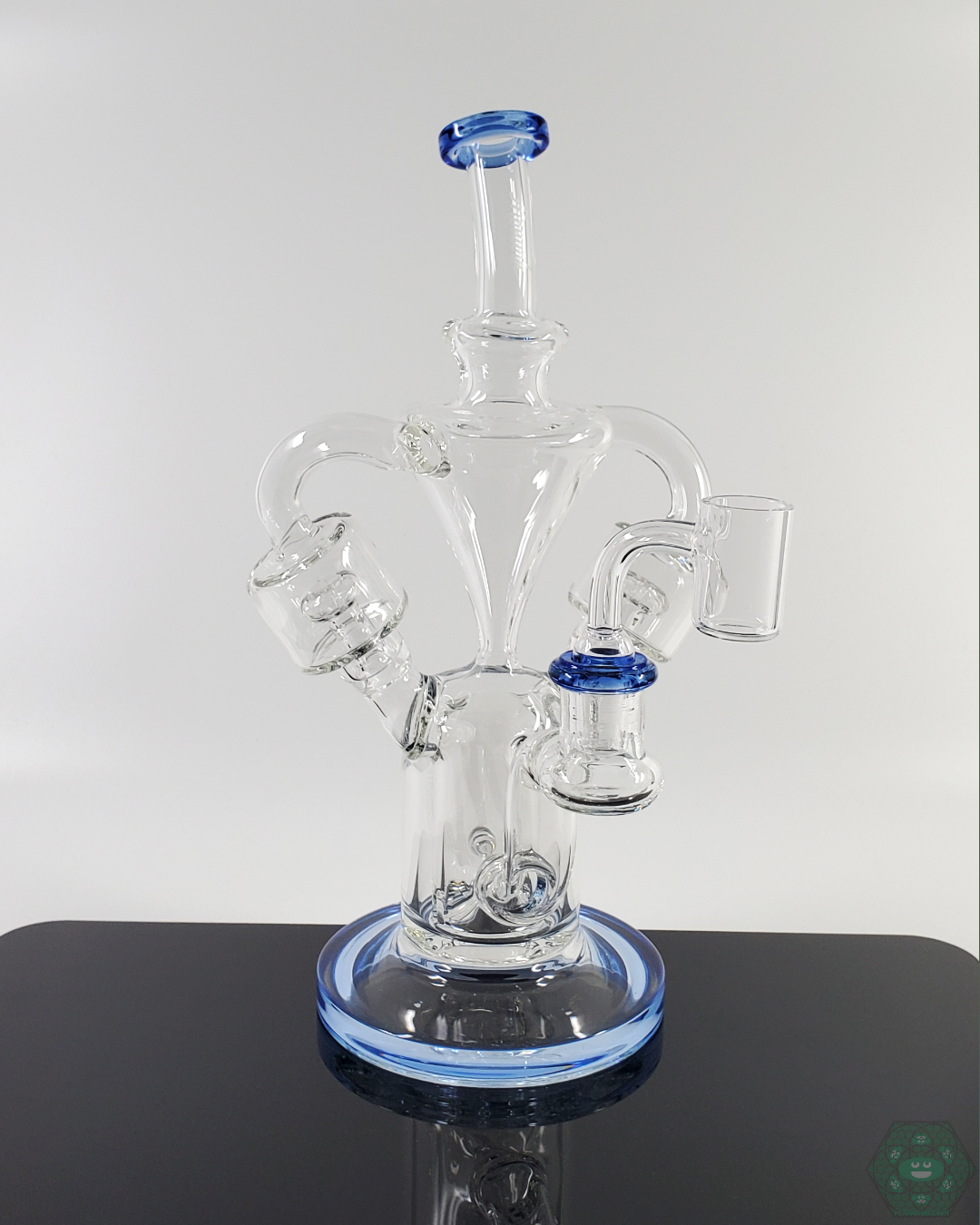 Monark Glass 9.5” Double Chamber Recycler - Dual Perc System for Smooth Filtration. Features 6-hole perc, 4-hole inline perc, 14mm male quartz bucket, 14mm female joint, internal drain, and dual uptake design.