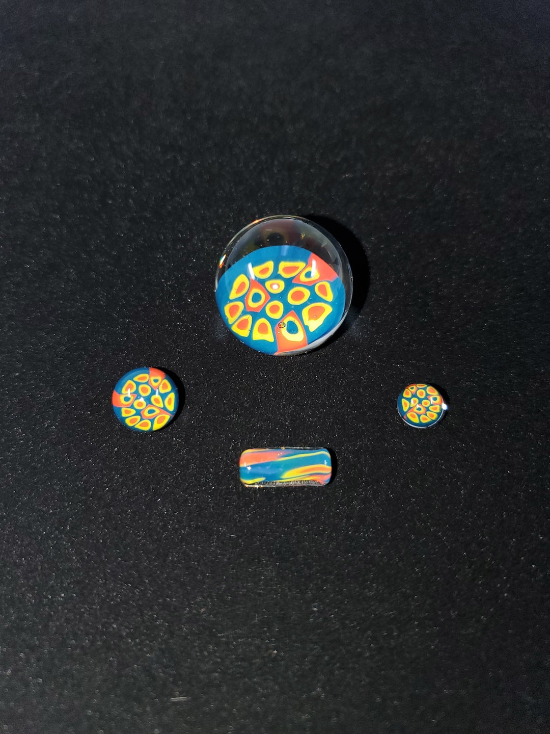 Parts of the Millennium Glass Slurper Set, including the terp slurper marble, pearls, and other components, showcasing the customizable elements for an enhanced dabbing setup.