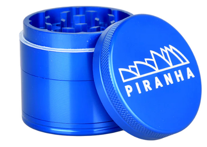  Piranha 2" 4-Piece Grinder made from anodized aluminum, featuring a magnetic closure, pollen chamber, and canvas carry pouch.