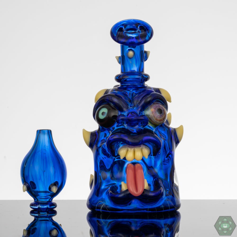 Kaleb Folck GPPR Open Mouth #337, an artisanal glass rig with UV-activated features, meticulously crafted with UV-reactive detailing, making it a standout piece, featuring a 10mm female joint with a single-hole gil perc for smooth draws, and including a matching bubble cap, ideal for any glass enthusiast's collection.