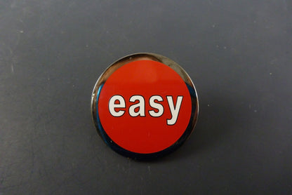 Fun “Easy Button” Style Pin, a lightweight and durable accessory that adds a playful touch to bags, hats, and casual wear.

