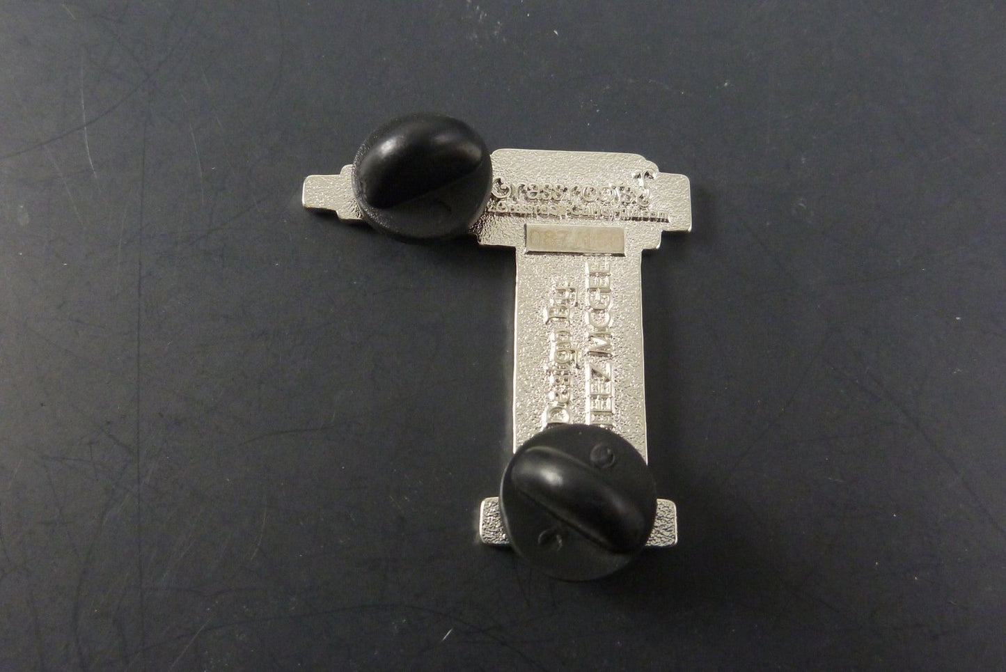 Close-up of the GRC Torch Pin, showcasing its high-quality enamel finish and detailed torch design, making it a stylish addition to any accessory collection.