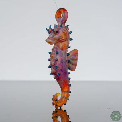Handcrafted Seahorse Pendant: This exquisite glass pendant by Liz Wright features a beautifully crafted seahorse, capturing the charm of ocean life in a wearable piece of art, perfect for adding a touch of the sea to any outfit.