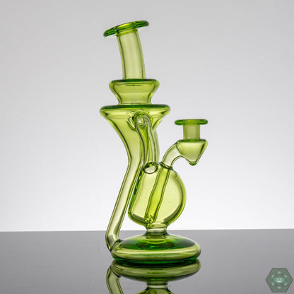  M Henny Absinthe Recycler, a 10mm dual uptake dab rig with a striking green tint, providing exceptional filtration and a smooth, flavorful pull, a top choice for those who value both performance and design.


