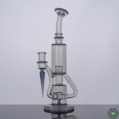 Parallax Bubble Dumper by The Glass Carpenter, a CFL reactive, premium heady glass rig featuring a 9-hole percolator, 14mm female 90-degree joint, standing at 10.75 inches, complete with a Headdy Mood Mat and a unique Parallax color shift, promising both style and performance for concentrate enthusiasts.