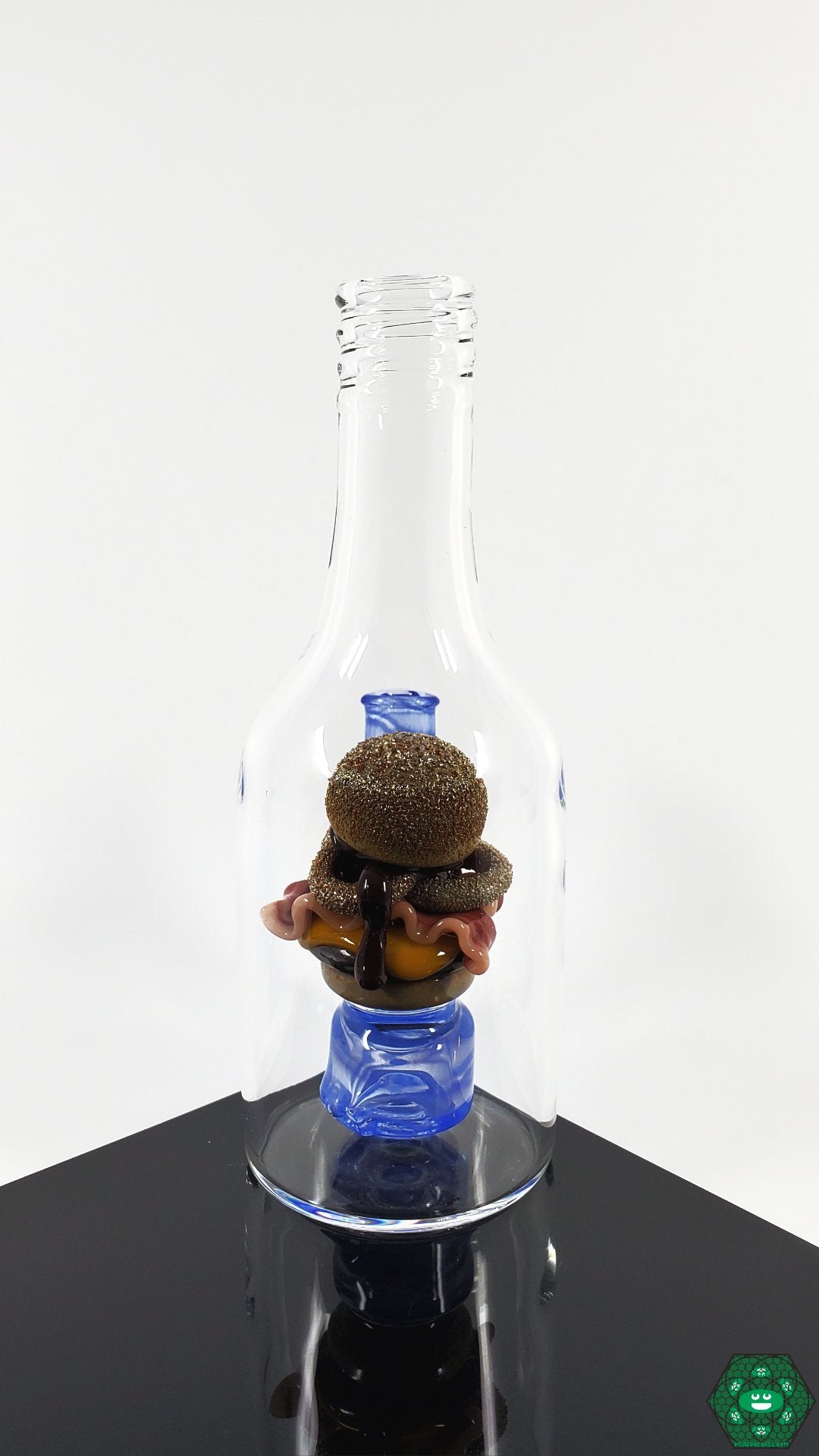 Rosburg Glass 5.75'' Bottle Rig – Blue #2 featuring a unique hamburger topper and 2-hole perc for smooth filtration and stylish flair.