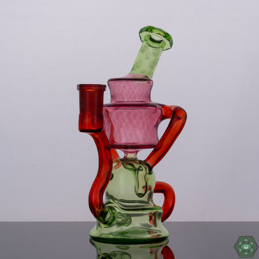 Wolfe Glass Double Single External Drain Recycler, a handcrafted 14mm dab rig with a precision external drain design, crafted from borosilicate glass for durability and aesthetic appeal, featuring a 14mm female 90-degree joint, dual uptake with single external drain for optimal airflow and superior filtration, a 4-hole perc for enhanced smoke diffusion, compact dimensions of 7.5 inches tall and 4-inch diameter, artistic color accents including Crushed Opal, Gold Ruby, Crippy, and Transparent Red, and includ