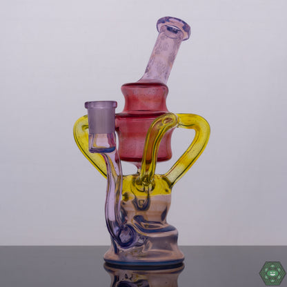 Wolfe Glass Triple Single Recycler, a 7.75" rig offering style and function with options like Phoenix Crushed Opal, Rose Quartz, Ghost, Citron, and Ghost with Crushed Opal, featuring a 4-hole perc, dual uptake, single external drain, and a faceted mouthpiece and joint, a 14mm 90-degree female rig providing powerful filtration and minimal splash, an exceptional collector’s piece for serious glass enthusiasts.
